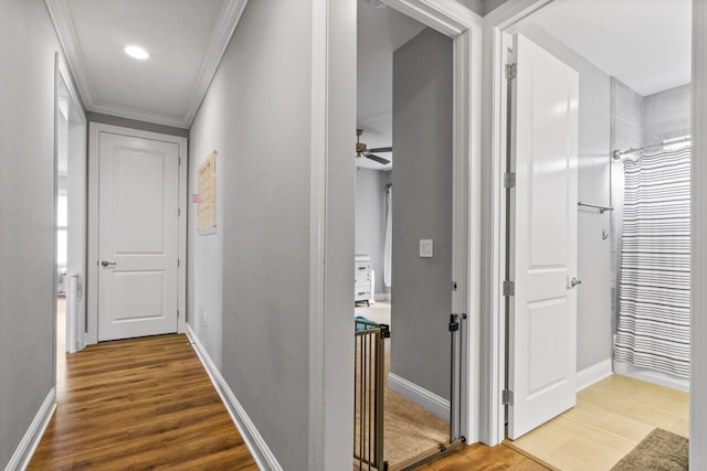 hall featuring wood-type flooring and crown molding