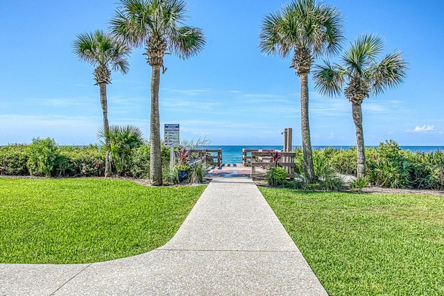 view of property's community with a lawn and a water view