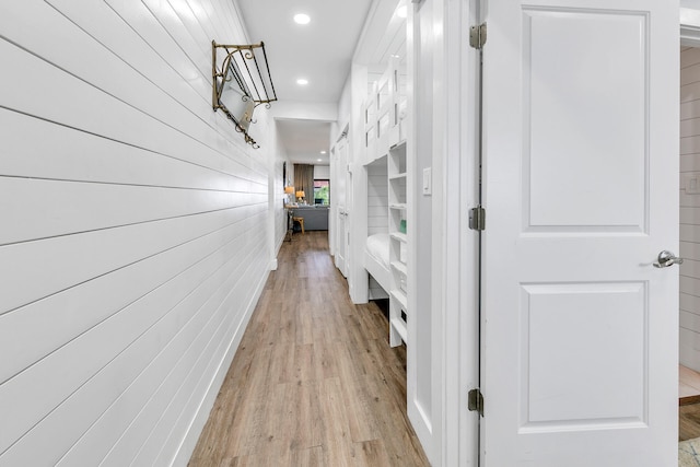 hallway featuring wooden walls and light wood-type flooring