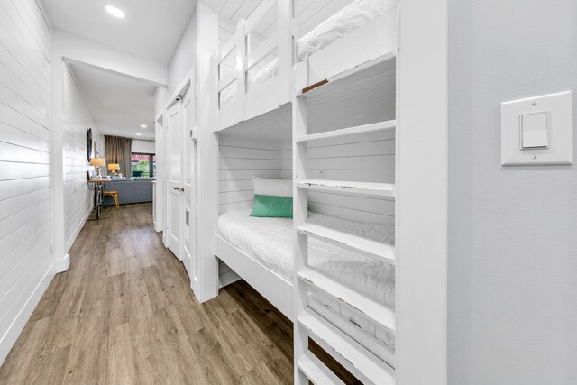 hallway with wooden walls and light hardwood / wood-style flooring