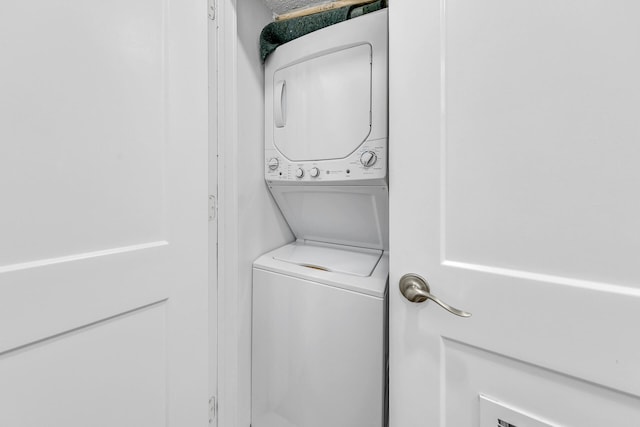 laundry room with stacked washing maching and dryer