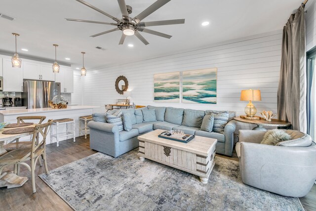 living room featuring ceiling fan and hardwood / wood-style flooring