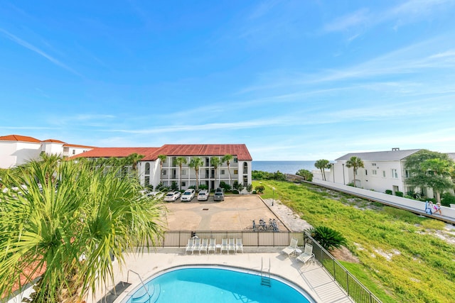 view of pool with a patio and a water view