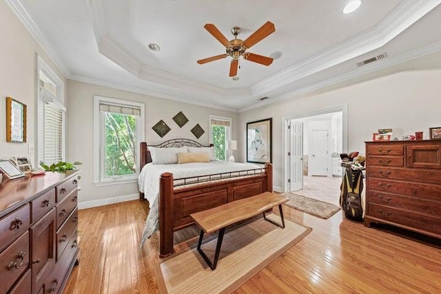 bedroom with a tray ceiling, ceiling fan, light hardwood / wood-style flooring, and crown molding