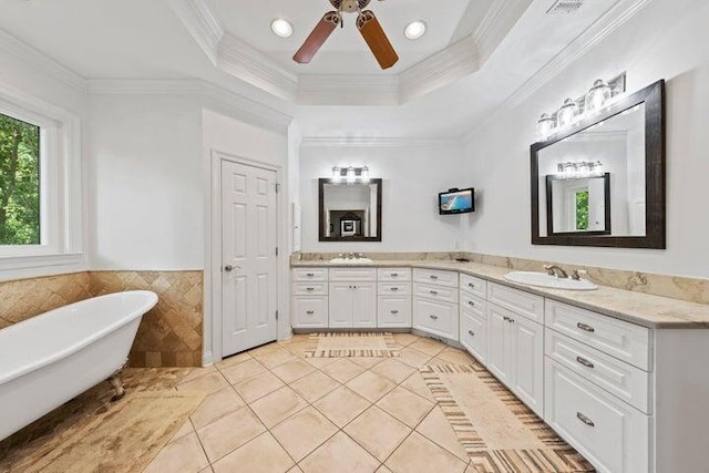 bathroom featuring vanity, a raised ceiling, ornamental molding, and tile walls