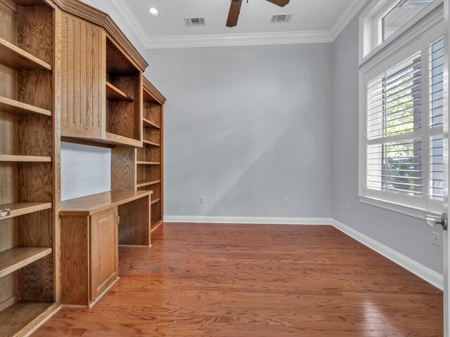 unfurnished office featuring dark hardwood / wood-style floors, ceiling fan, and crown molding