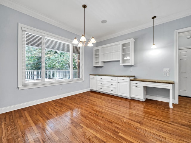 kitchen featuring white cabinetry, crown molding, hanging light fixtures, and light wood-type flooring