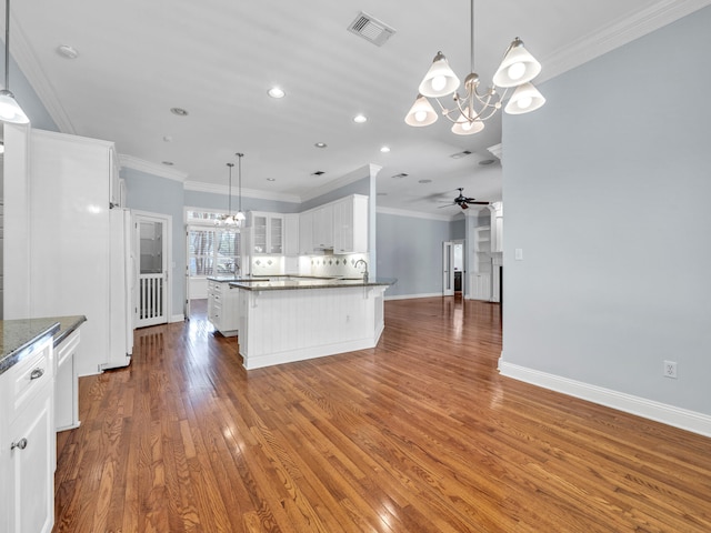 kitchen featuring ceiling fan with notable chandelier, pendant lighting, white fridge, white cabinets, and dark hardwood / wood-style floors