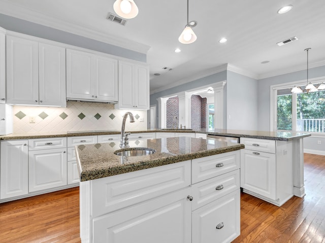 kitchen with sink, an island with sink, and light hardwood / wood-style floors