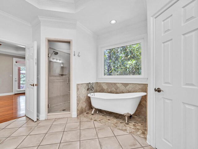 bathroom featuring tile patterned floors, crown molding, independent shower and bath, and tile walls