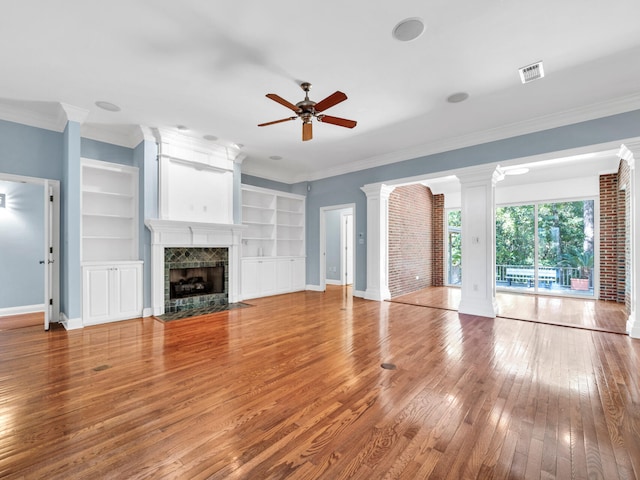 unfurnished living room featuring a tile fireplace, hardwood / wood-style floors, ceiling fan, and ornamental molding