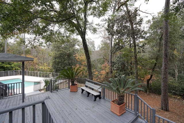 wooden deck with a fenced in pool