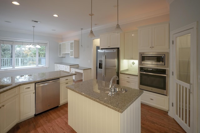 kitchen with white cabinets, decorative light fixtures, stainless steel appliances, and a kitchen island with sink