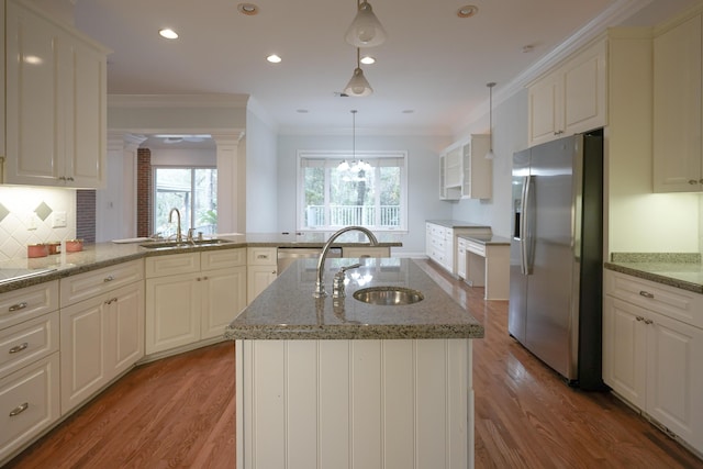 kitchen with a kitchen island with sink, decorative light fixtures, hardwood / wood-style flooring, and appliances with stainless steel finishes