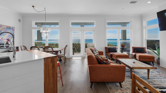 living room with a wealth of natural light, hardwood / wood-style floors, and a chandelier