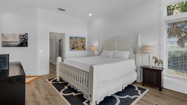 bedroom with wood-type flooring and ornamental molding