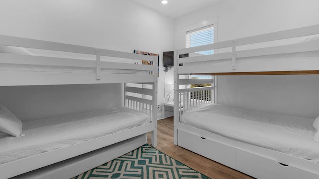 bedroom with wood-type flooring and multiple windows