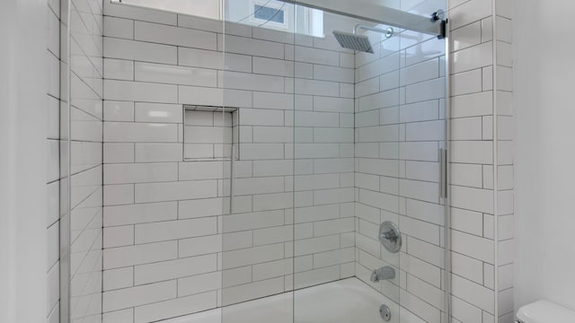 bathroom featuring toilet and tiled shower / bath