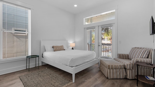 bedroom with access to exterior, french doors, and wood-type flooring