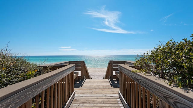 view of property's community featuring a water view and a beach view