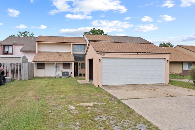 view of front of property featuring central AC, a front yard, and a garage