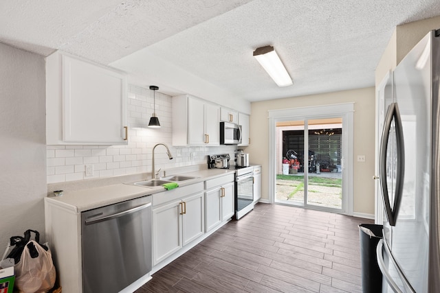 1840 E Mallard Dr Apt C, Panama City, FL 32404 - kitchen with white cabinetry, light countertops, decorative backsplash, a sink, and appliances with stainless steel finishes
