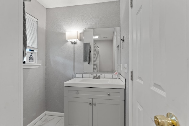 1840 E Mallard Dr Apt C, Panama City, FL 32404 - bathroom with baseboards, marble finish floor, a textured wall, and vanity