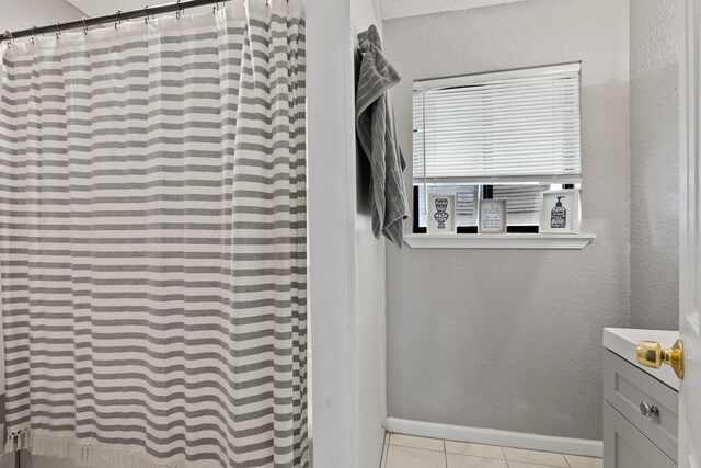 bathroom featuring vanity, walk in shower, and tile patterned flooring