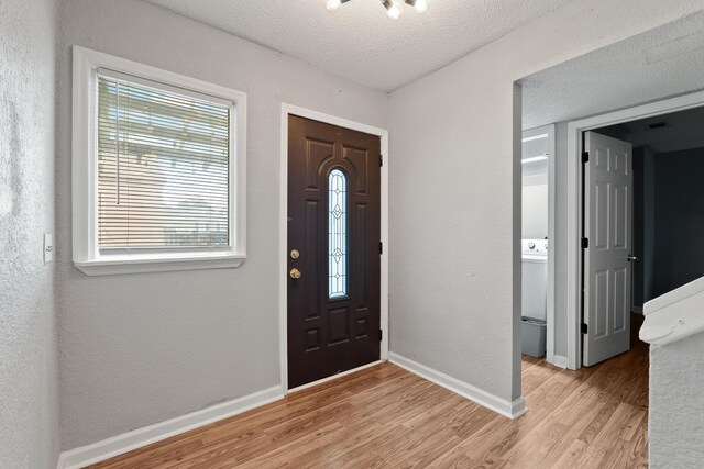 foyer featuring a textured ceiling and light hardwood / wood-style flooring