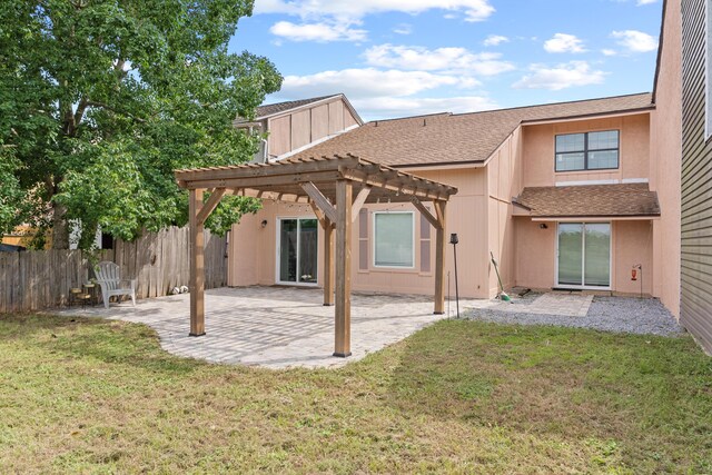 rear view of house with a pergola, a lawn, and a patio