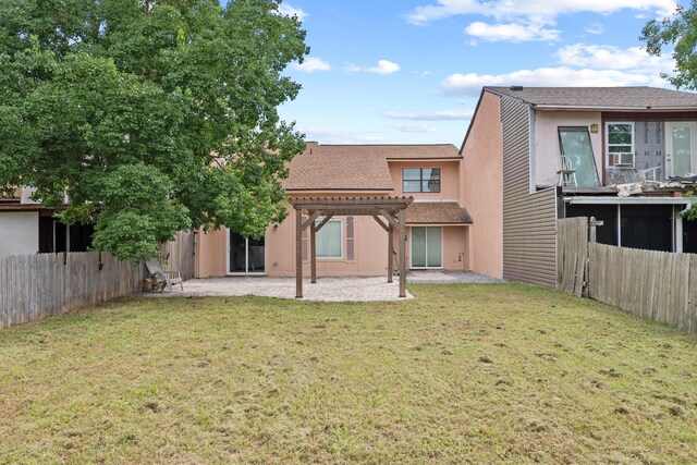 back of property with a pergola, a yard, and a patio