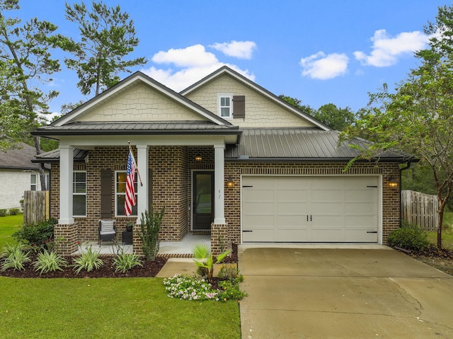 view of front facade featuring a garage, a front yard, and covered porch