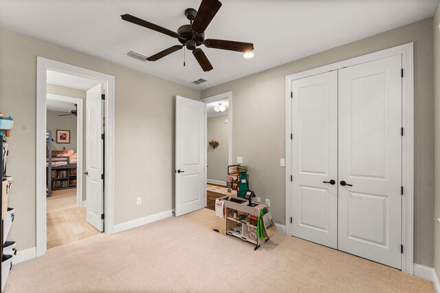 interior space featuring ceiling fan and light carpet