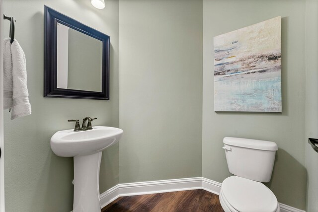 bathroom featuring toilet, sink, and hardwood / wood-style floors