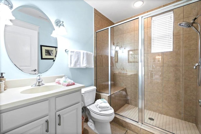 full bathroom featuring a stall shower, toilet, and vanity