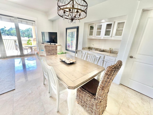 dining area with crown molding, sink, and a notable chandelier