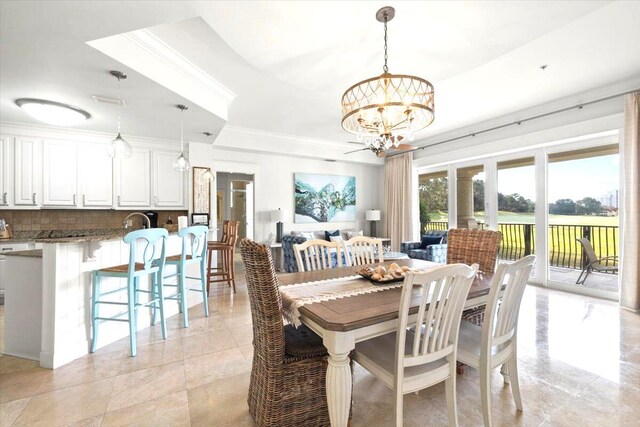 dining space with a raised ceiling, crown molding, and a chandelier