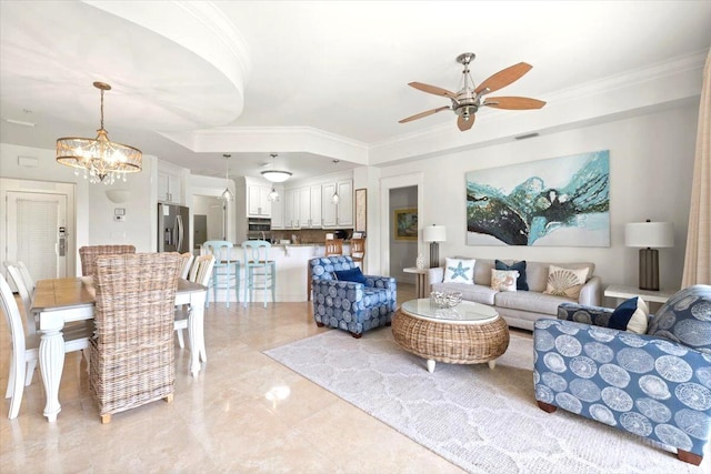 living area with a tray ceiling, visible vents, ornamental molding, and ceiling fan with notable chandelier