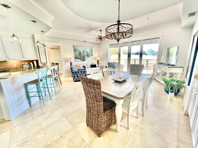 dining space featuring a tray ceiling and ceiling fan with notable chandelier