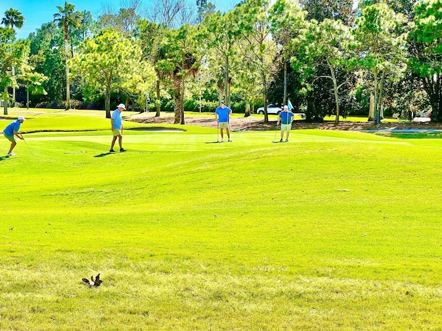 view of home's community featuring a yard and view of golf course