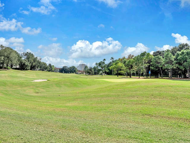 view of property's community with a yard and view of golf course