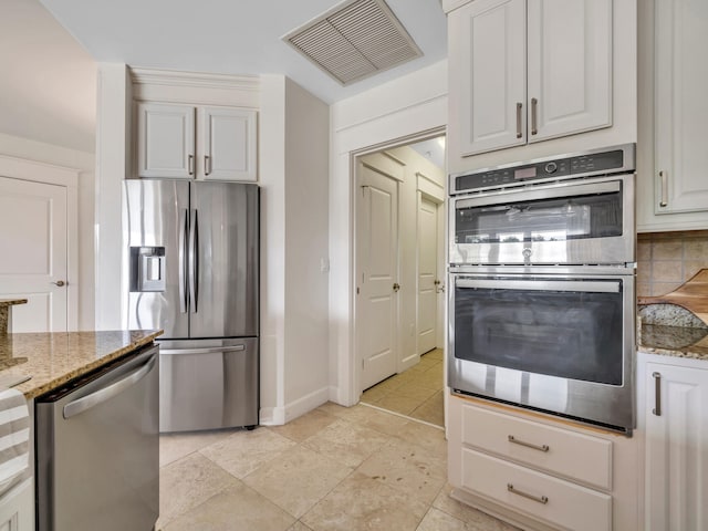 kitchen featuring light tile patterned floors, light stone countertops, visible vents, decorative backsplash, and appliances with stainless steel finishes