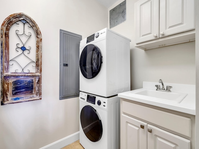 laundry room featuring stacked washer and dryer, a sink, electric panel, cabinet space, and baseboards