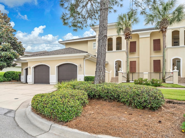 view of front of house featuring stucco siding, concrete driveway, and a garage