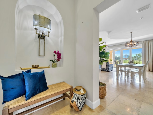 hall with an inviting chandelier, baseboards, and visible vents