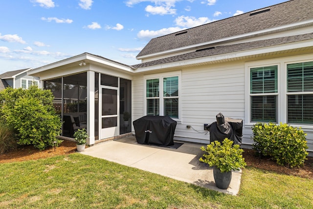 rear view of house with a sunroom, a yard, and a patio