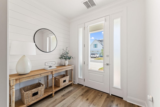 entryway with crown molding and light hardwood / wood-style floors