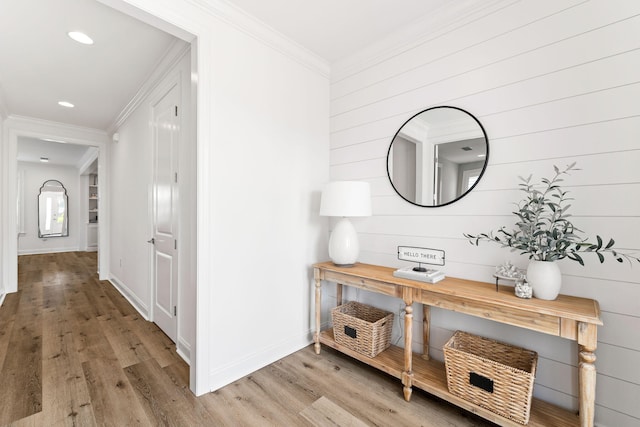 corridor featuring light wood-type flooring and ornamental molding