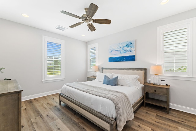 bedroom with multiple windows, hardwood / wood-style floors, and ceiling fan