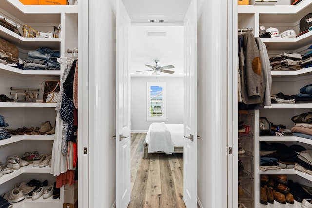 walk in closet with ceiling fan and wood-type flooring